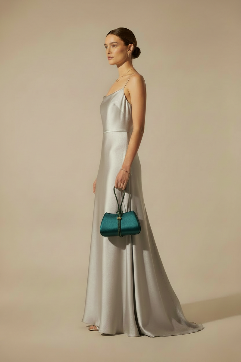 Model in sleeveless silver gown carrying TE AMO bag